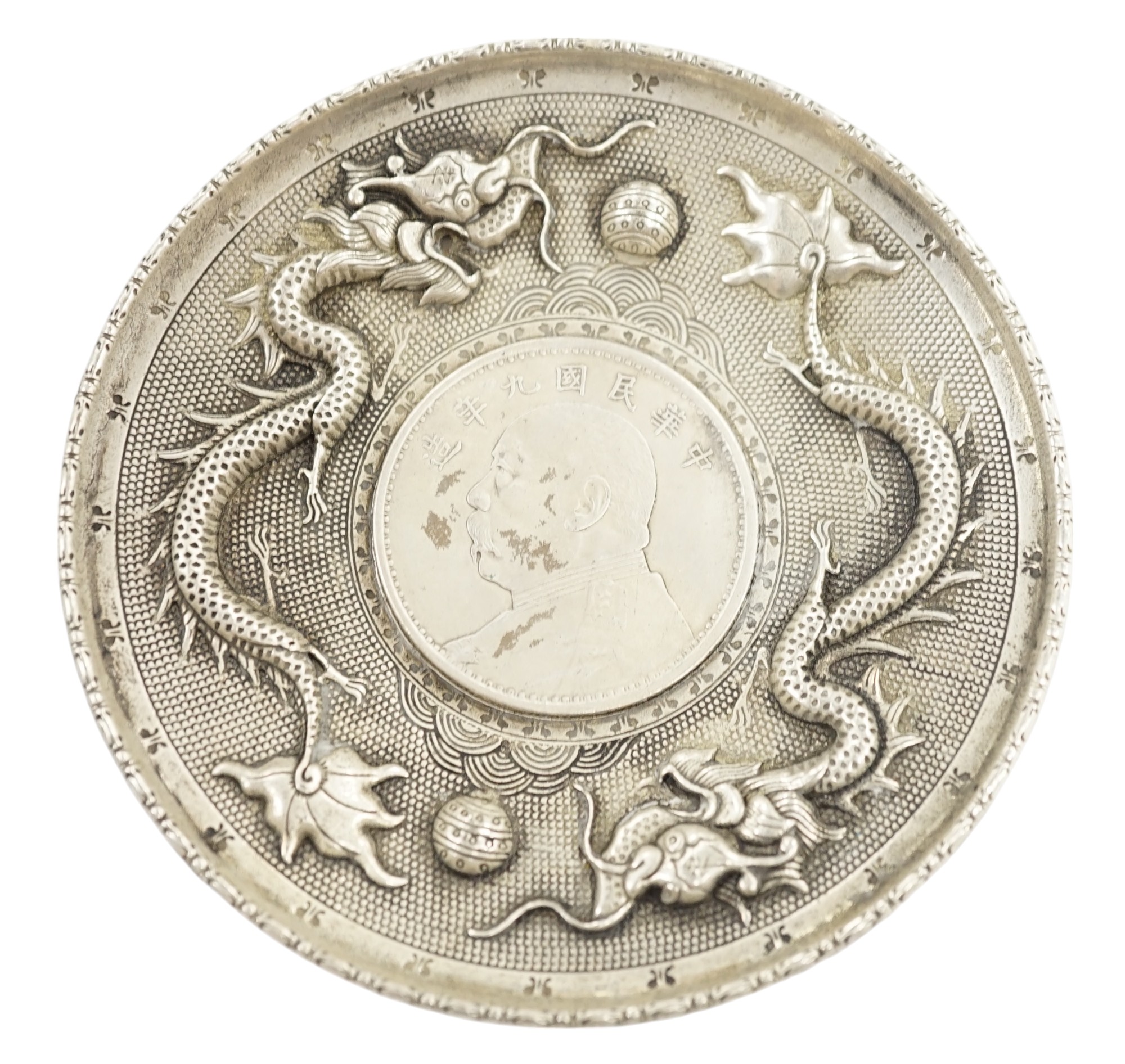 A Chinese white metal dish inset with Yuan Shikai coin, 10.1cm. Condition - fair